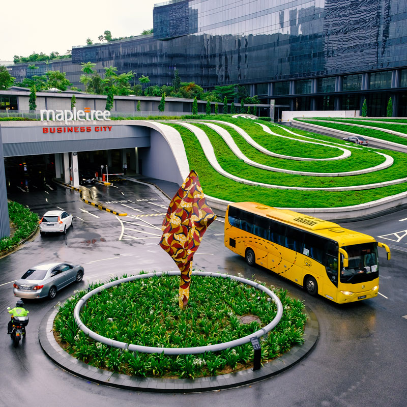 Bus in circle at Mapletree Business City in Singapore on a rainy day.